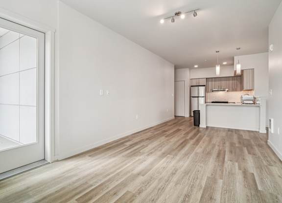 A room with a white wall and a wooden floor.