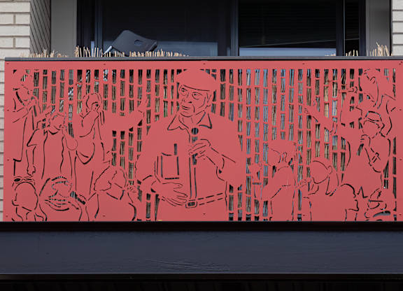 A red metal screen with black outlines of people and trees.