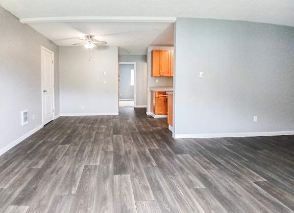 A room with wooden flooring and a ceiling fan.