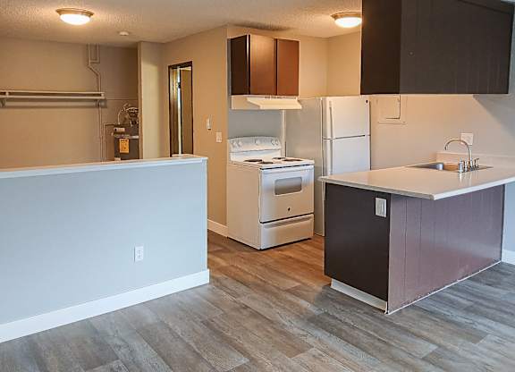A kitchen with a white fridge and a white stove top oven.