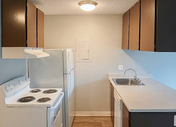 A kitchen with a white stove and refrigerator.