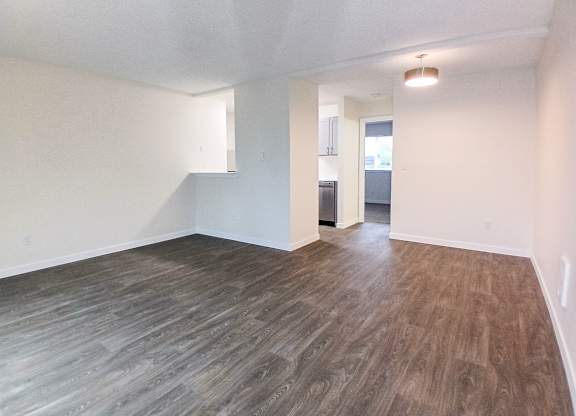 A room with wooden flooring and white walls.