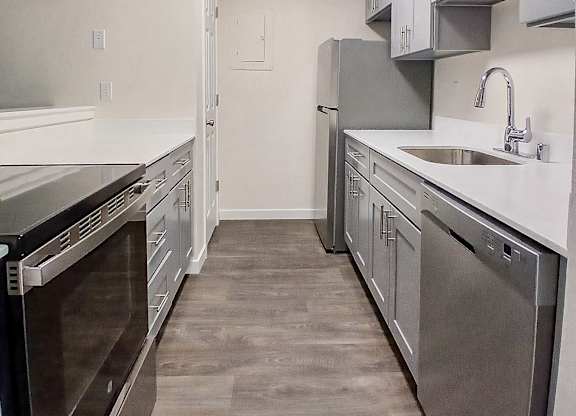 A kitchen with a stainless steel dishwasher and oven.