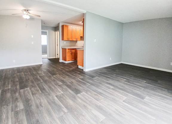 A room with wooden flooring and a ceiling fan.