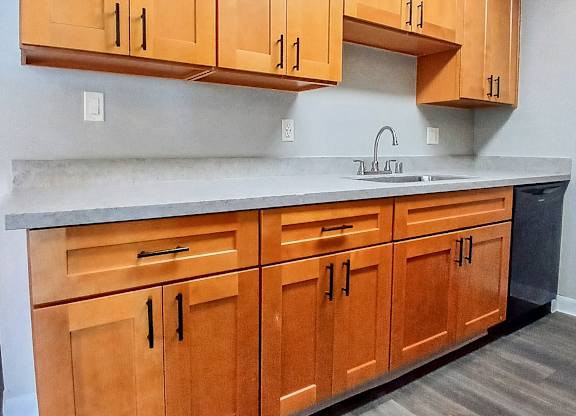 A kitchen with wooden cabinets and a sink.