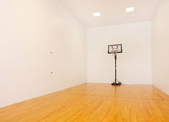 A basketball hoop stands in a large empty room.