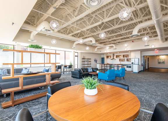 A large room with a wooden table in the center and blue chairs.