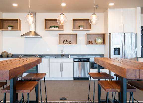 A modern kitchen with a wooden table and stools.
