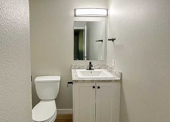 A white toilet sits next to a sink in a small bathroom.