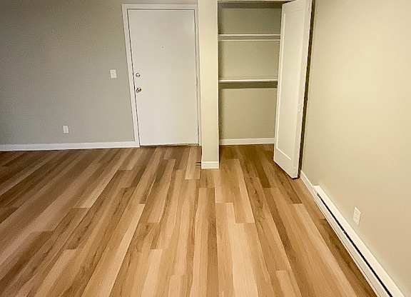 A room with a ceiling fan and wooden flooring.