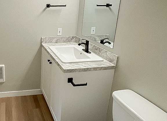 A white toilet sits next to a sink in a small bathroom.