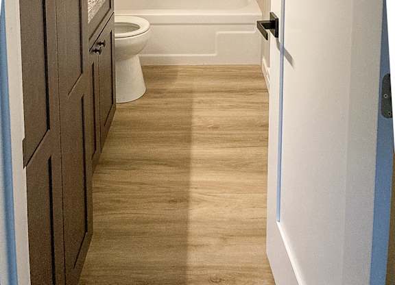 A small bathroom with a toilet, sink and bathtub.