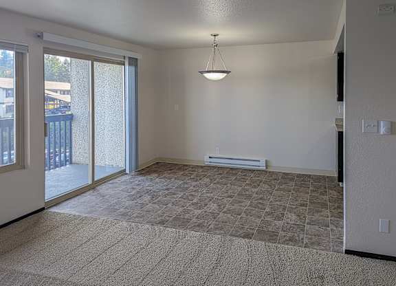 A room with a carpeted floor and a hanging light fixture.