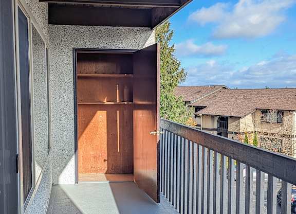 A balcony with a blue floor and a wooden door.
