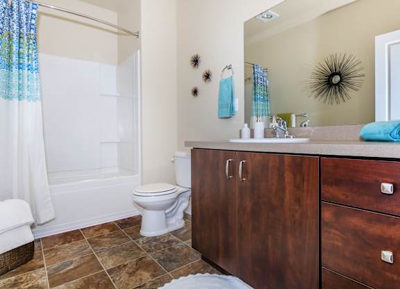 A bathroom with a toilet, sink, and shower.