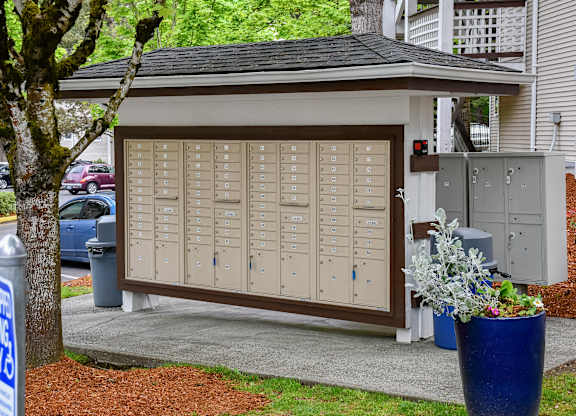 A brown and beige garage door with a tree in front of it.