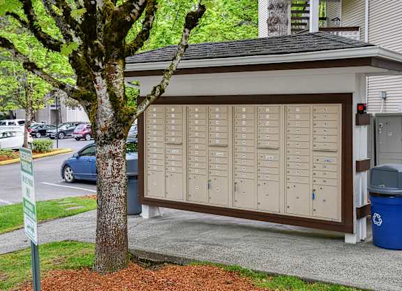 A brown and white garage door with a tree in front of it.