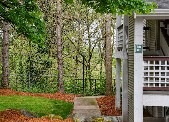 A green tree in front of a house.