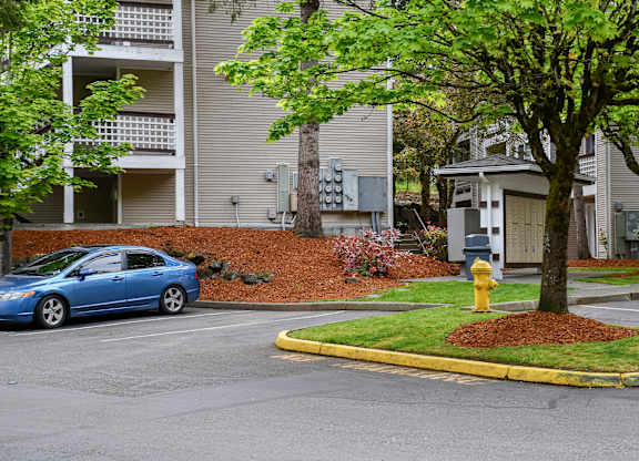 A blue car is parked in front of a building.