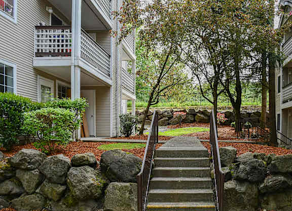 A stone staircase leads up to a balcony in a residential building.