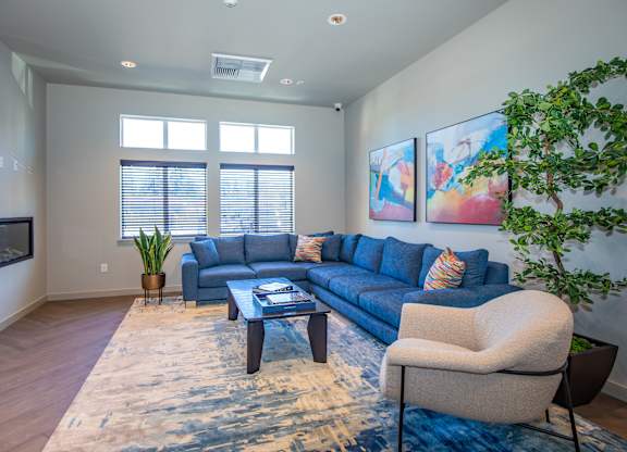 A living room with a blue couch, a coffee table, and a rug.