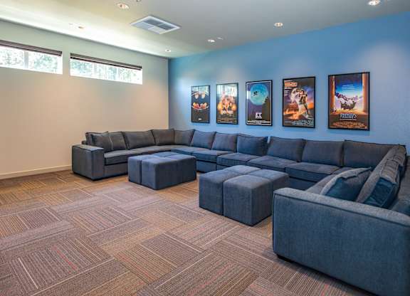 A living room with a grey sofa and ottoman.