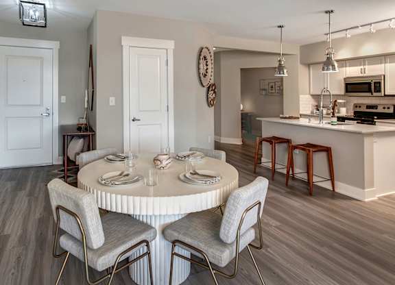 A dining room with a round table and chairs.