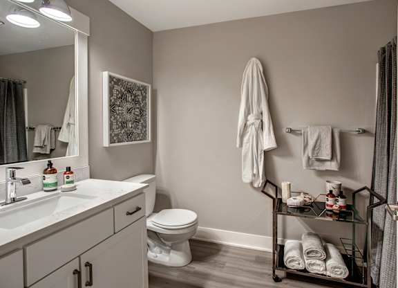 A bathroom with a toilet, sink, and towel rack.