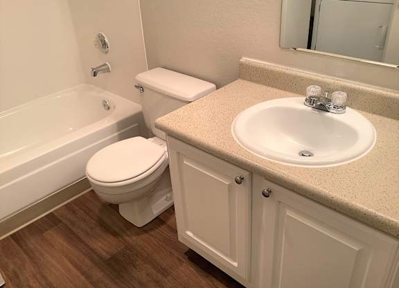 A white toilet sits next to a sink in a bathroom.