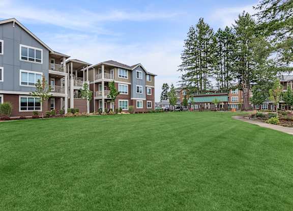 A large grassy area in front of apartment buildings.