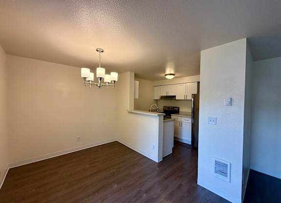 A kitchen area with a counter and cabinets is visible from the living room.