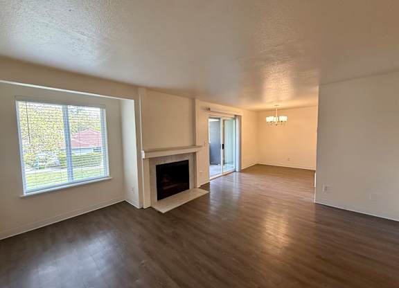 A living room with a fireplace and a sliding glass door.