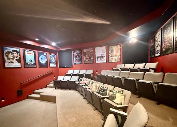 A movie theater with rows of seats and posters on the wall.