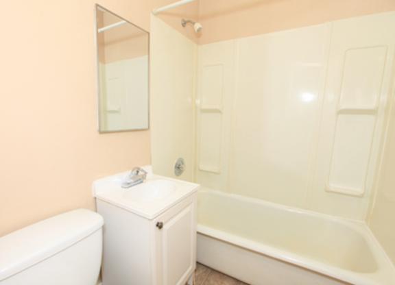 A white toilet sits next to a white sink in a bathroom.