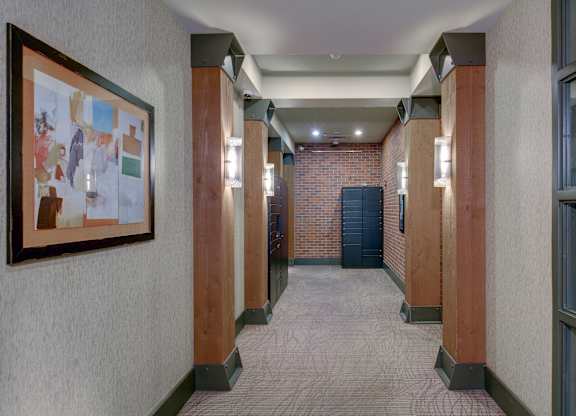 A hallway with a brick wall and a framed picture on the wall.