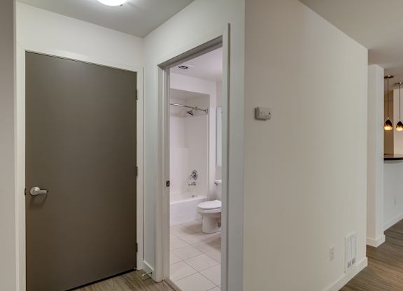 A bathroom with a toilet and sink is visible through an open door.