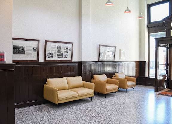 A waiting room with a row of chairs and pictures on the wall.