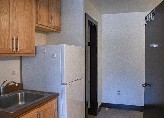 A kitchen with a sink and a refrigerator.