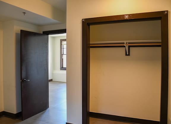 A large mirror with a black frame is leaning against a wall in a room.