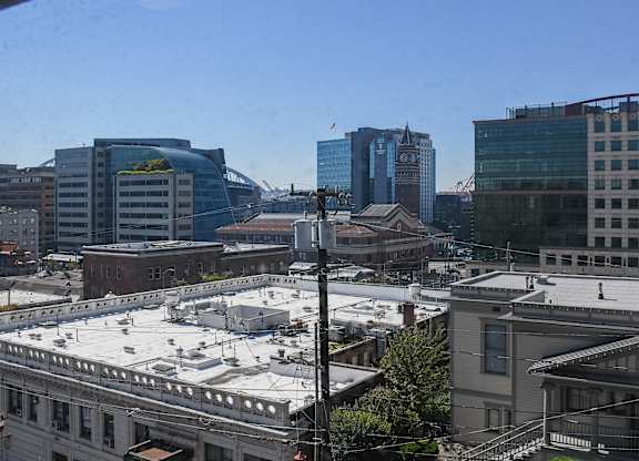 A cityscape with a mix of modern and older buildings under a clear sky.
