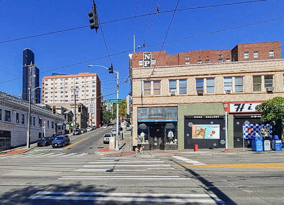 A street view with a car on the road and buildings on the side.