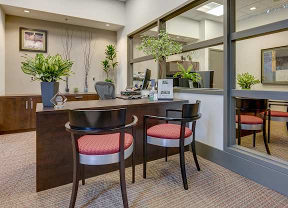 A reception area with a desk and two chairs.