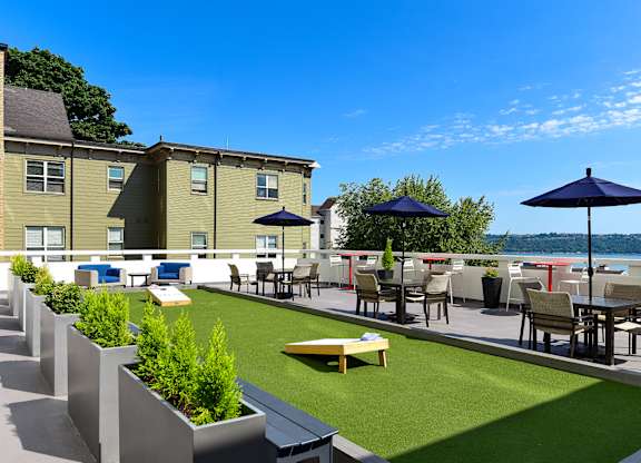 A patio with a table and chairs overlooking a body of water.