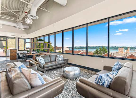 A living room with two couches and a large window overlooking a cityscape.