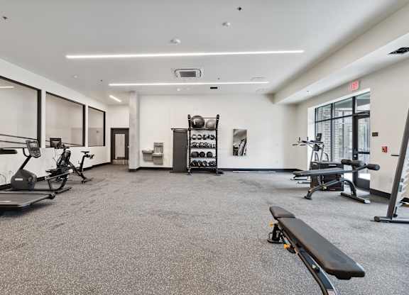 A spacious gym with a variety of equipment including treadmills, exercise bikes, and weight racks.