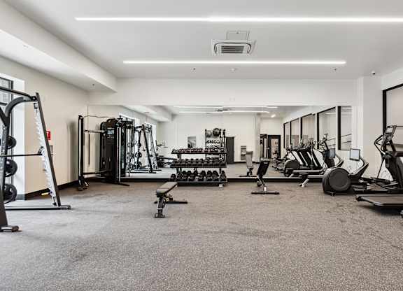 A spacious gym with a variety of equipment including treadmills, weights, and exercise machines.