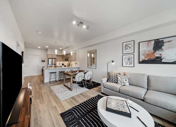 A modern living room with a grey couch, a wooden coffee table, and a flat screen TV.