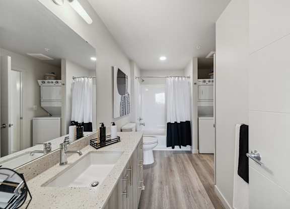 A modern bathroom with a double sink vanity and a walk-in shower.
