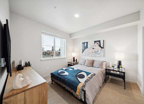 A bedroom with a bed, nightstand, and a television.