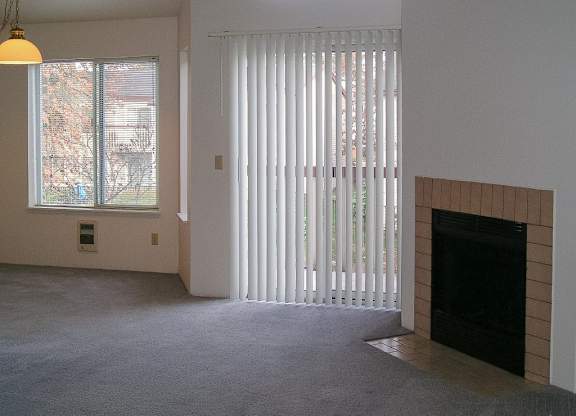 A room with a fireplace and a window with blinds.